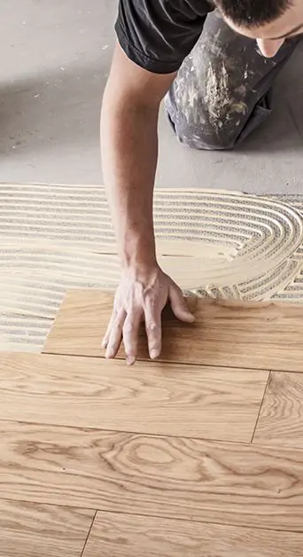 Photo d'une personne entre train de poser un parquet contre-collé